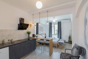 eine Küche und ein Wohnzimmer mit einem Tisch und Stühlen in der Unterkunft Nereid Apartment in Athen