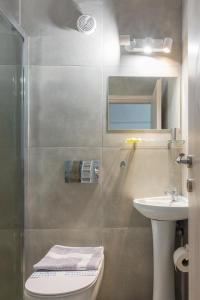 ein Bad mit einer Dusche, einem WC und einem Waschbecken in der Unterkunft Nereid Apartment in Athen