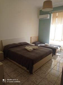 a bedroom with two beds and a window at La casa del Professore in Catania