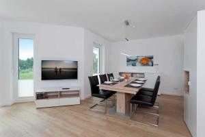 a dining room with a table with chairs and a television at Ferienhaus Alt Sallenthin 10 B, "Sonne" in Neu Sallenthin