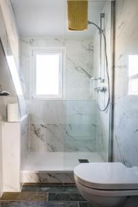 La salle de bains blanche est pourvue d'une douche et de toilettes. dans l'établissement La Palmeraie, rénové, central et proche plage, à Dieppe