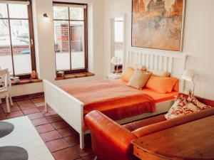 ein Schlafzimmer mit einem Bett und einer Couch in der Unterkunft Backsteinparadies in Lüneburg