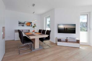 a dining room with a table and chairs and a television at Ferienhaus Alt Sallenthin 10 A, "Sand" in Neu Sallenthin