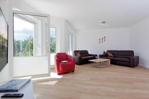 a living room with a couch and a red chair at Ferienhaus Alt Sallenthin 10 A, "Sand" in Neu Sallenthin