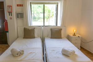 - 2 lits dans une petite chambre avec fenêtre dans l'établissement Quinta Agave, à Almádena