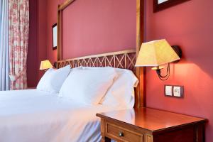 1 dormitorio con 1 cama y 1 mesa con lámpara en Hotel Fontecruz Ávila, en Ávila