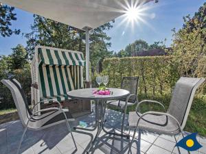 a table and chairs on a patio with an umbrella at Haus Meeresrauschen Whg 03 in Bansin