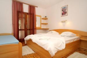 - une chambre avec un lit doté de draps blancs et une fenêtre dans l'établissement Apartments by the sea Ivan Dolac, Hvar - 8700, à Jelsa
