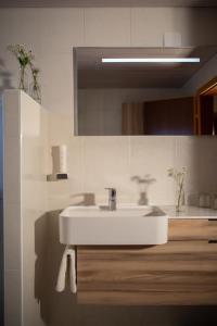 ein weißes Badezimmer mit einem Waschbecken und einem Spiegel in der Unterkunft Gasthof Abfalter in Golling an der Salzach