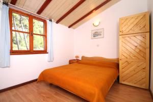 una camera da letto con un letto con una coperta arancione di Apartments by the sea Ivan Dolac, Hvar - 8711 a Jelsa (Gelsa)