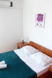 a bedroom with a bed with a green and white at Apartments and rooms with parking space Hvar - 8717 in Hvar