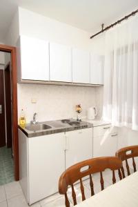 a kitchen with white cabinets and a sink at Apartments and rooms with parking space Hvar - 8717 in Hvar