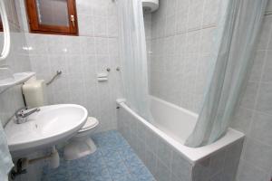 a bathroom with a sink and a tub and a toilet at Apartments and rooms with parking space Hvar - 8717 in Hvar