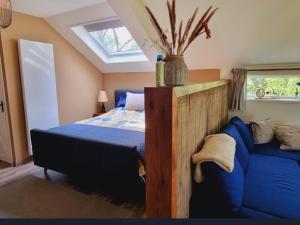 a bedroom with a bed and a blue couch at Slapen bij Bonanza in Bantega