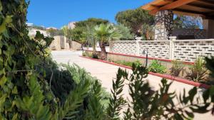a garden with a white fence and palm trees at Mamalù Deluxe in Lampedusa