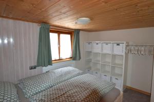 sypialnia z łóżkiem i drewnianym sufitem w obiekcie Steibinger Bergnest w mieście Oberstaufen