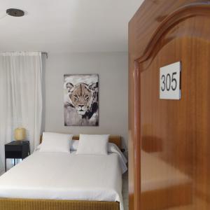 a bedroom with a bed and a picture of a tiger at La Palmera Rooms in Alhaurín el Grande