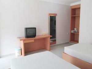 Habitación con 2 camas y escritorio con TV. en Pelangi Hotel & Resort en Tanjung Pinang
