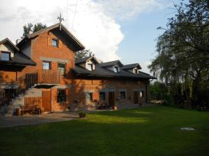 a large brick building with a grass yard at Dwór w Boleniu in Bolen