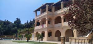 a large building with a fence in front of it at BOSCO VERDE Corfu Apartments in Gouvia