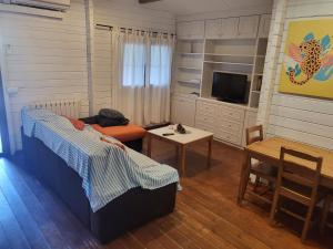 1 dormitorio con cama, mesa y TV en Casa Madera Urbanizacion Socorro, en Sevilla