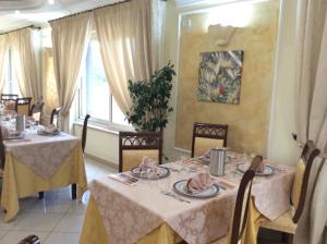 uma sala de jantar com duas mesas e cadeiras em Cridda Hotel & Restaurant em Gizzeria
