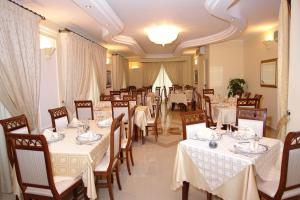 a dining room with white tables and chairs at Cridda Hotel & Restaurant in Gizzeria