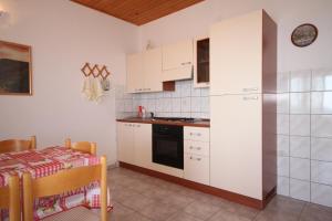 a kitchen with white cabinets and a table at Apartments with a parking space Ivan Dolac, Hvar - 8797 in Ivan Dolac