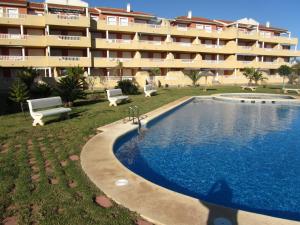 a hotel with a swimming pool in front of a building at Apartment Deveses Park in Denia