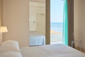 - une chambre avec un lit et une vue sur la plage dans l'établissement Hotel delle Nazioni, à Pesaro