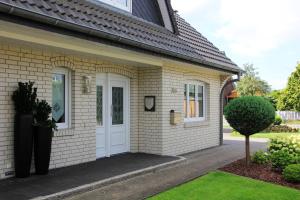 Casa de ladrillo aige con puerta blanca en Ferienhaus Uggelharde en Tarp