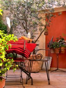 une chaise rouge avec une couverture rouge sur une table dans l'établissement B&B in Arles "L'Atelier du Midi" chambre d'hôtes centre historique ARLES, à Arles