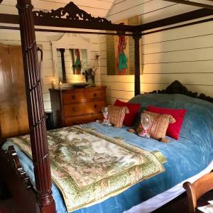 a bedroom with a canopy bed and a dresser at The Garden Room in Ringwood
