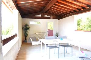 d'une terrasse avec une table et des chaises blanches. dans l'établissement Le Patio Bleu, à La Crau