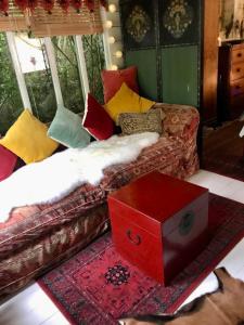 sala de estar con sofá y caja roja en The Garden Room, en Ringwood