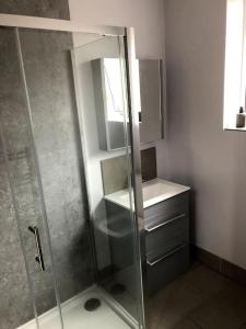 a bathroom with a glass shower and a sink at 2 Bedroom Bungalow in Mawdesley