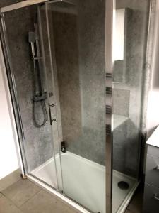 a shower with a glass door in a bathroom at 2 Bedroom Bungalow in Mawdesley