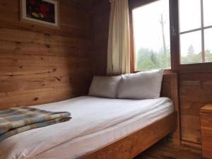 a bed in a log cabin with a window at Kardelen Bungalov Evleri̇ in Ayder Yaylasi