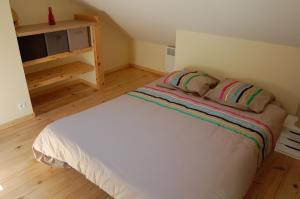 a bedroom with a white bed with two pillows at La Petite Maison in Campsegret