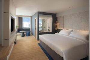 ein Schlafzimmer mit einem großen weißen Bett und einem Fernseher in der Unterkunft Miracle Grand Convention Hotel in Bangkok
