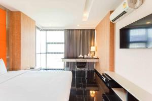a hotel room with a bed and a flat screen tv at ibis Styles Chiang Mai in Chiang Mai