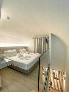 Barbie Hotel Apartments في إياليسوس: غرفة نوم بسرير ذو شراشف بيضاء
