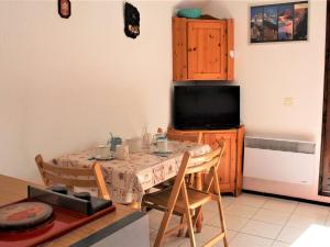 a kitchen with a table with chairs and a television at Appartement Vars, 2 pièces, 4 personnes - FR-1-330B-69 in Vars