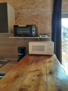eine Mikrowelle auf einem Holztisch in der Unterkunft Studio dans bâtisse typique du Jura 