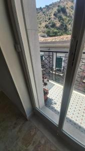 una porta aperta con vista su un balcone di Nido Azzurro a Scaletta Zanclea