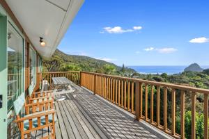 a balcony with benches and a view of the ocean at Seaview, Sun and Surf - Piha Holiday Home in Piha