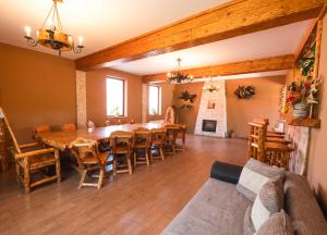 a dining room with a table and chairs and a couch at Casa de vacanta Sadu in Sadu