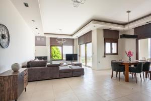 uma sala de estar com um sofá e uma mesa em Bay Overlook Akrotiri em Korakiaí