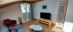 a living room with a couch and a tv at Chalet Sunnmätteli in Wilderswil