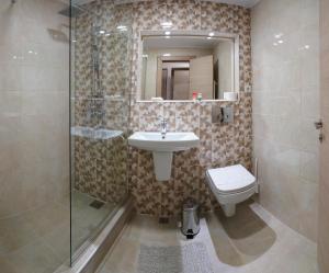 a bathroom with a sink and a toilet and a shower at Hotel Tiara in Ploieşti